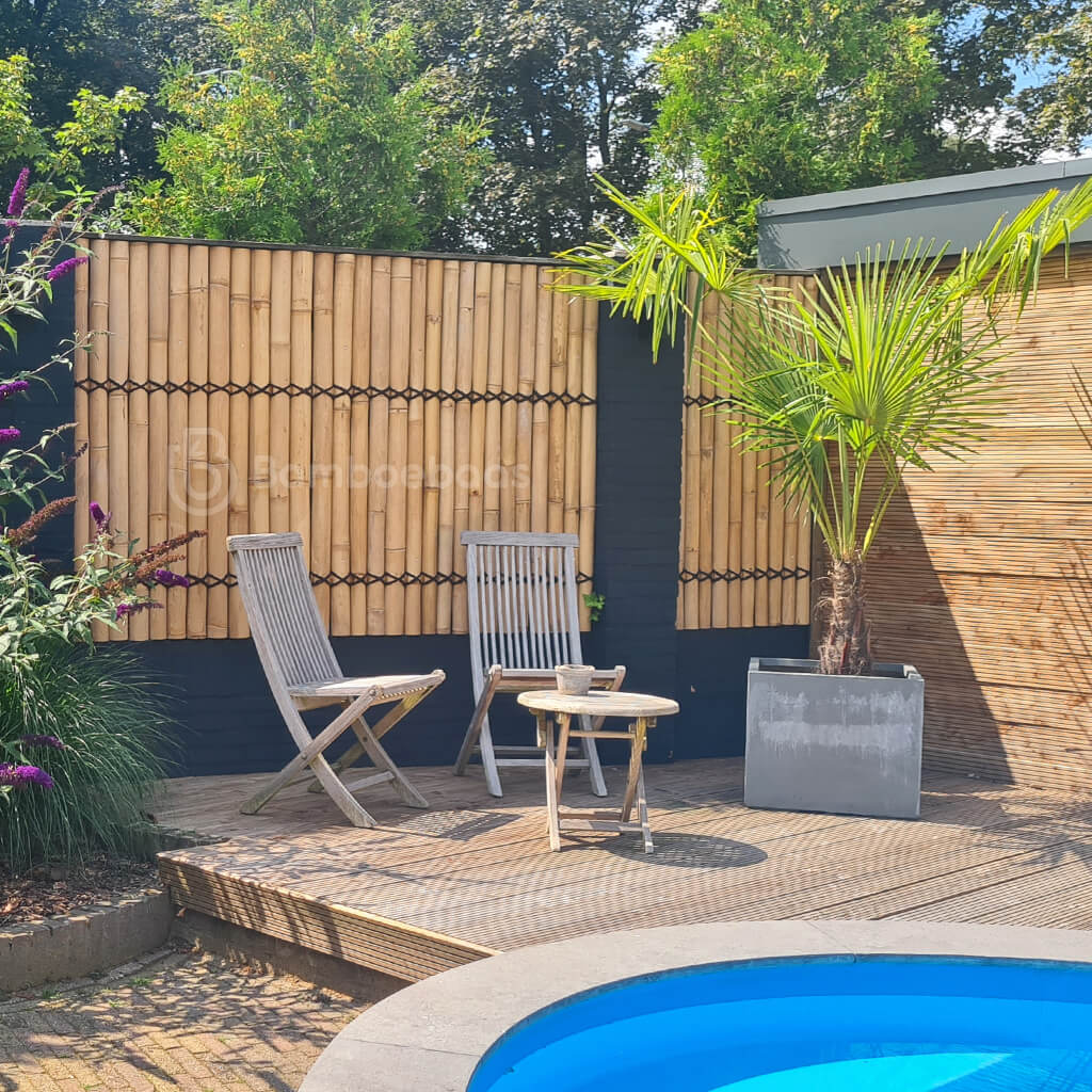 Halfronde bamboe schutting met palmtouw in tropische tuin