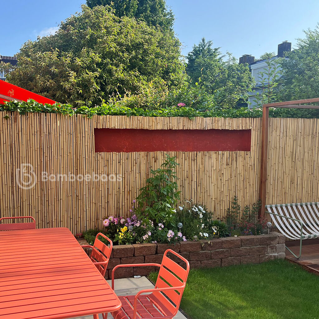 Bamboemat Midi - Naturel tegen een bestaande schutting